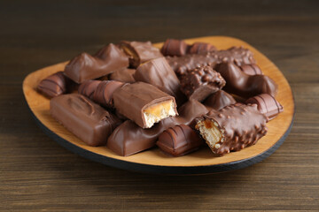 Tasty chocolate bars on wooden table, closeup