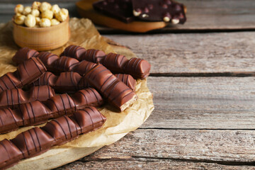 Tasty chocolate bars on wooden table, space for text