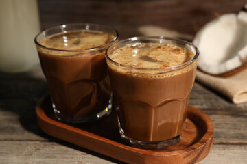 Glasses of tasty coffee on wooden table, closeup