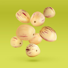 Fresh ripe pepino melons falling on yellow green background
