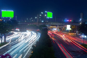 Fototapeta na wymiar Time lapse photo at Dien Bien Phu street, Ho Chi Minh city with billboards with green background