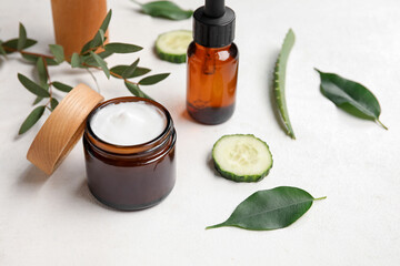 Natural cosmetic products, ingredients and plant leaves on light background