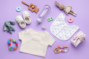 Composition with baby clothes, toys and accessories on lilac background