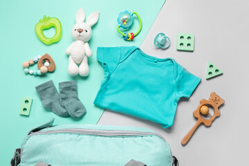 Composition with baby clothes and toys on turquoise background