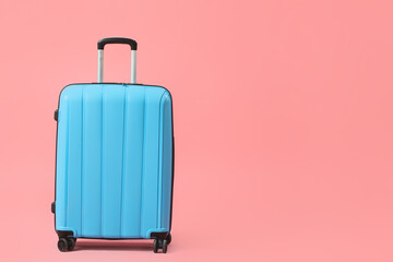 Blue suitcase on pink background