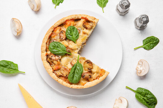 Mushroom pie with spinach leaves and champignons on white background