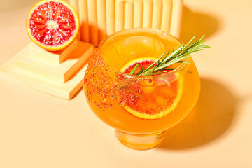Fresh summer cocktail with grapefruit and rosemary on orange background