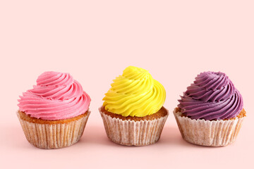 Tasty colorful cupcakes on pink background