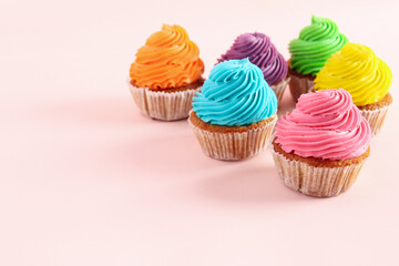 Tasty colorful cupcakes on pink background