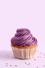 Tasty cupcake on purple background