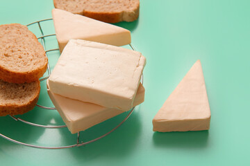 Stand with processed cheese and bread on turquoise background