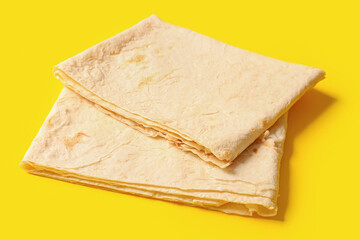 Fresh thin lavash on yellow background