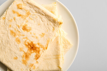 Plate with fresh thin lavash on grey background