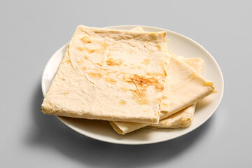 Plate with fresh thin lavash on grey background