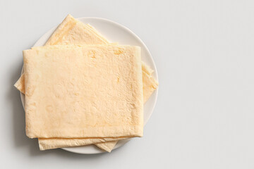 Plate with fresh thin lavash on grey background