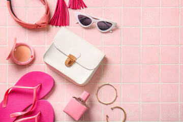 Fototapeta na wymiar Stylish bag and different accessories on pink tile background
