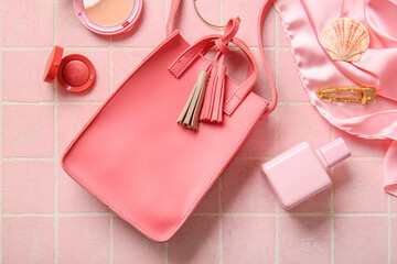 Stylish bag and different accessories on pink tile background