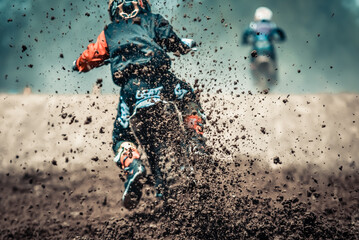Details of mud and debris in a motocross race, Motocross rider accelerating on dirty track with mud...