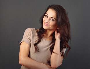 Fototapeta premium Beautiful makeup toothy enjoying smiling woman with long brown healthy curly hair style in fashion shirt clothing. Closeup studio portrait on grey