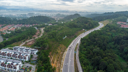Aerial view of residential area with green asphalt road and residential houses directly above viewpoint. View of suburbs and city district. Real estate and housing market concept. - 601572456