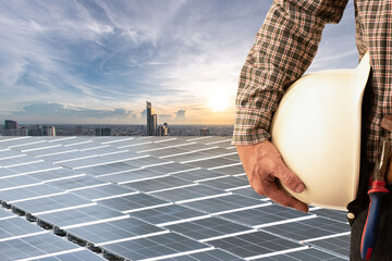 Engineer standing beside solar panel and modern city skyline.