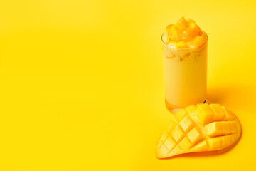 Juicy Mango Smoothie with fresh mango slices on yellow background.Thai Sweet mango smoothie.Summer...