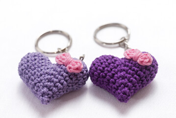 A pair of crocheted purple heart-shaped keyrings on a white background