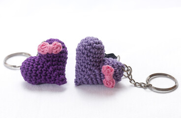 A pair of crocheted purple heart-shaped keyrings on a white background