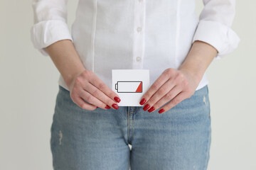 Woman in jeans and shirt shows discharged battery cell image