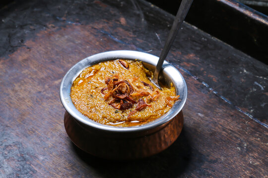 Mathrooba Chicken haleem, halim with fried onion served in dish isolated on red mat top view on table arabic food