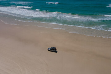 Fototapeta na wymiar Aerial view of beach driving with a 4WD vehicle on Moreton Island