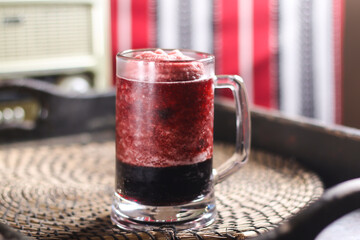 Vimto drink, or femto syrup served in mug isolated on red mat top view on table arabic drink