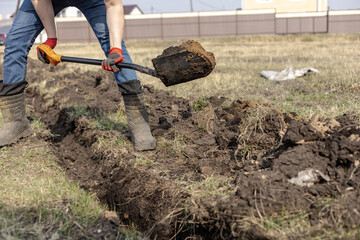 Drainage ditch. A man is digging a ditch. Laying a drainage pipe. Earthwork. A Worker digs soil...