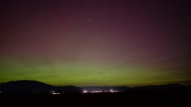 Time Lapse - Escalating Aurora Australis above small town lights