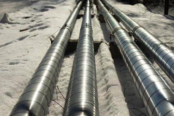 Pipes on street in winter. Steel heating pipes. Industry details.