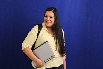 Dark-haired latin adult woman uses laptop for work, online shopping, dating in apps looks excited and points finger