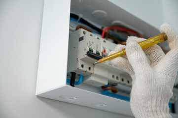 Close-up of a panel breaker. An electrician is testing electrical power and installing electrical switches in homes and buildings.