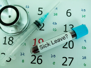 Blood sample in a tube with label sick leave on a monthly planner appointments. Blood tests labeled sick leave