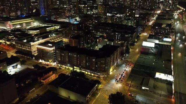 High angle view of streets and biddings in night city. Tilt up reveal of skyline with illuminated downtown skyscrapers. San Francisco, California, USA