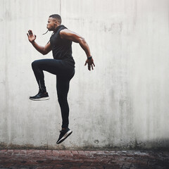 Jump, fitness and black man running, speed and energy for cardio training, workout and sports wellness or body health. Athlete, runner or person exercise on concrete wall, action run or moving in air - obrazy, fototapety, plakaty