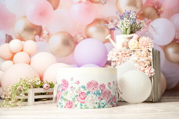 pink and white decoration for a 1st birthday cake smash studio photo shoot with balloons, paper decor, cake and topper