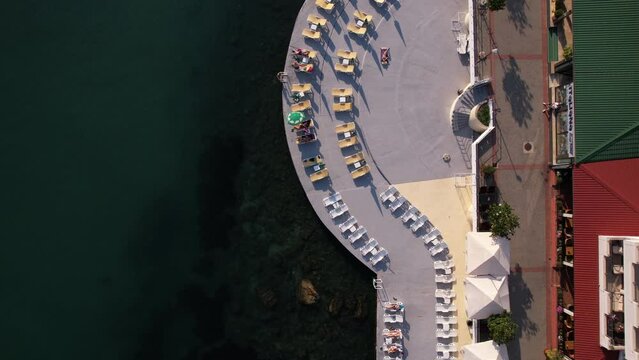 Top Down Aerial View of Seaside Promenade, Parasols amd People Sunbathing on Hot Summer Day, High Angle Drone Shot