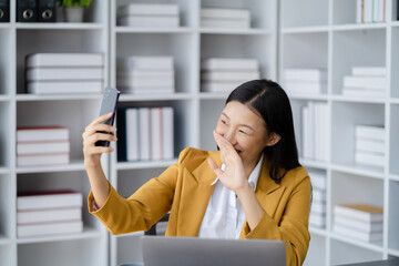 Happy businesswomen holding phone looking at screen waving hands video call friend online in mobile chat app using smartphone videochat application.