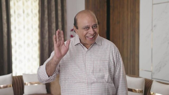 Happy old Indian uncle waving Hi to the camera