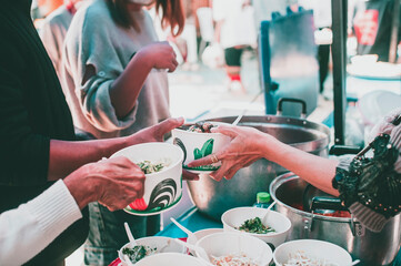 Volunteers offer free food to the poor: the concept of food sharing.