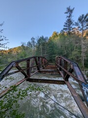 Fototapeta na wymiar Nature's Beauty: A Rusty Bridge Over a Flowing River