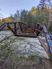 Nature's Beauty: A Rusty Bridge Over a Flowing River
