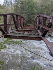 Nature's Beauty: A Rusty Bridge Over a Flowing River