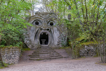 The ancient statue representing the ogre, in the park of monsters in Bomarzo, Italy - obrazy, fototapety, plakaty