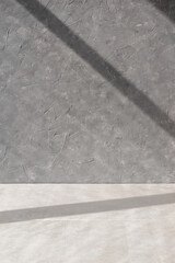 Empty gray concrete wall texture and beige stone floor with sun light shadow, blank home room...
